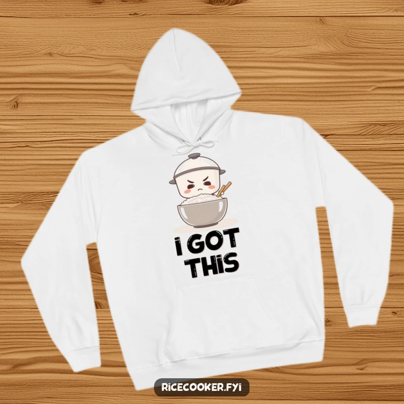 Funny warm hoodie with a determined rice cooker focused on stirring a massive bowl of rice, inspiring effort.