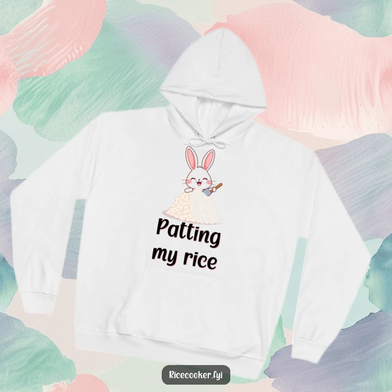 Funny joyful bunny patting a mound of rice with a tiny spatula, looking proud and happy, a cozy funny hoodie.